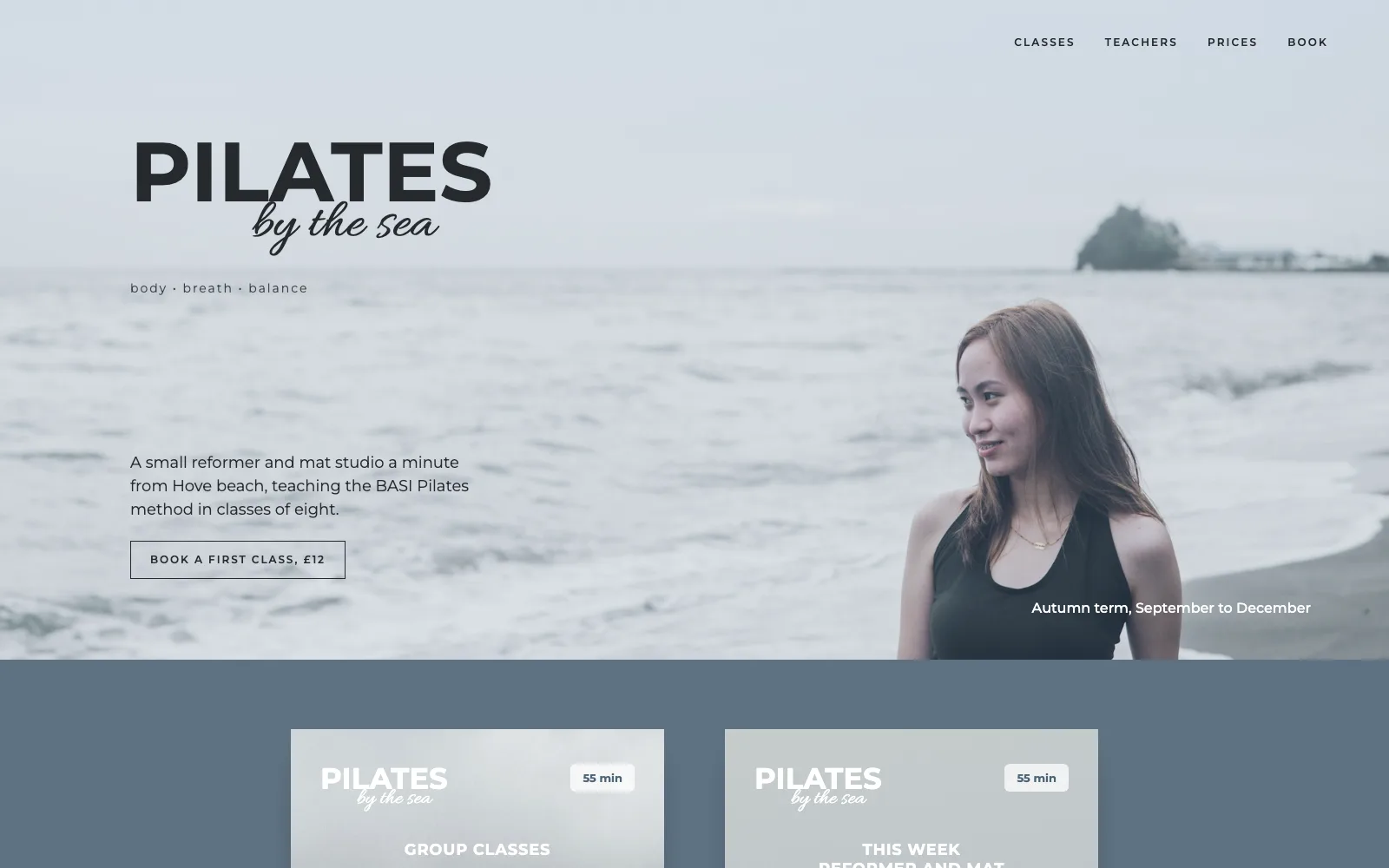 Saltwater Pilates homepage: PILATES by the sea over a misty beach where a woman holds a tree pose, then price and timetable cards on slate blue.