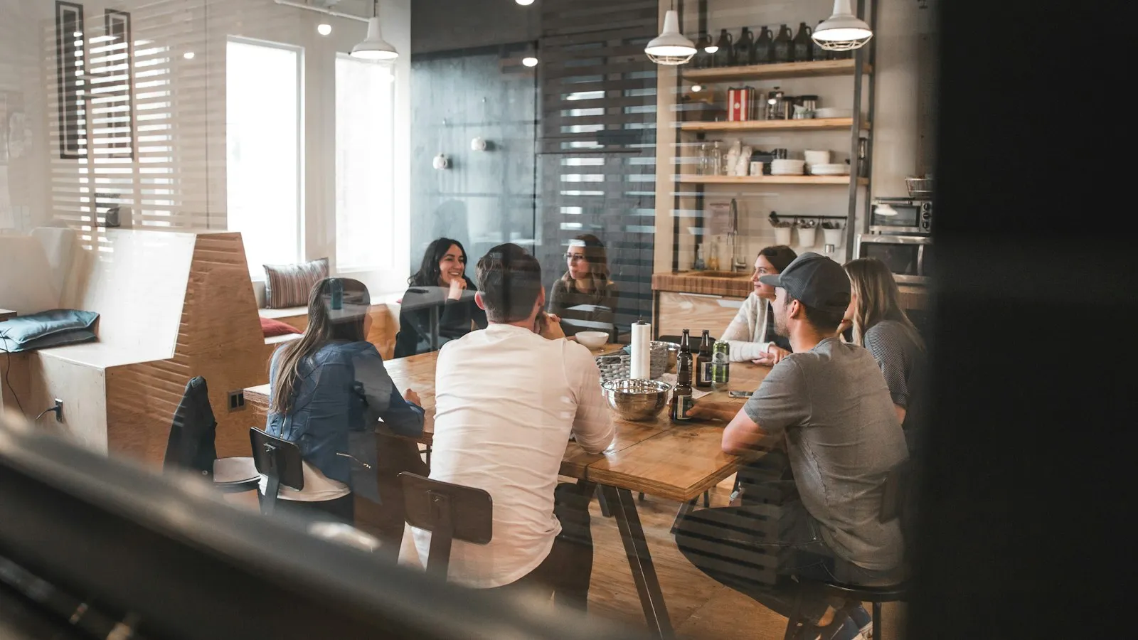 A small team meeting around a table in a bright office.